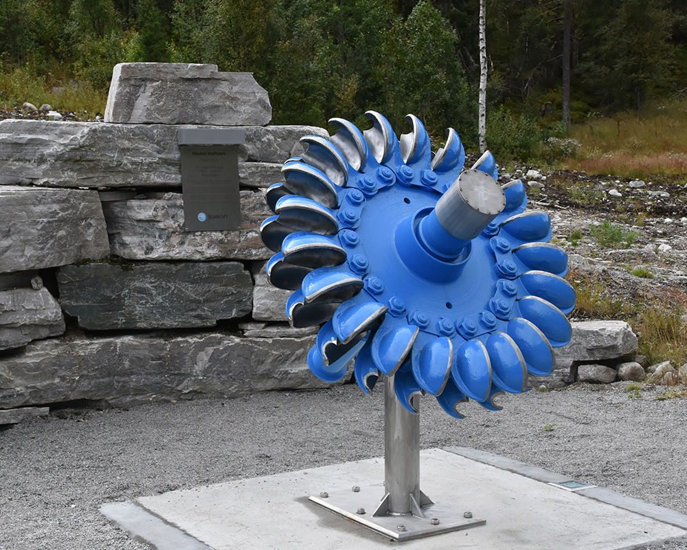 An old turbine runner and a commemorative plaque celebrate over 50 years of operation for the old Haukeli power plant